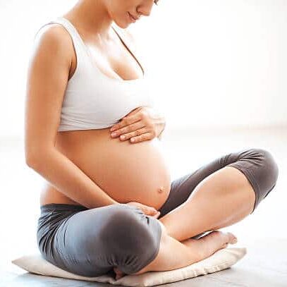 Pregnant woman is doing some stretches and exercise