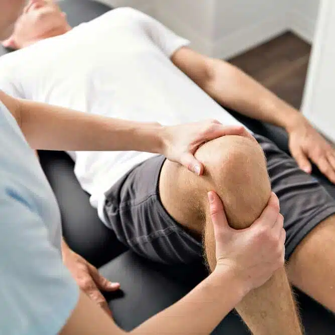 Athlete suffers from a sports injury getting a treatment in a chiropractic clinic