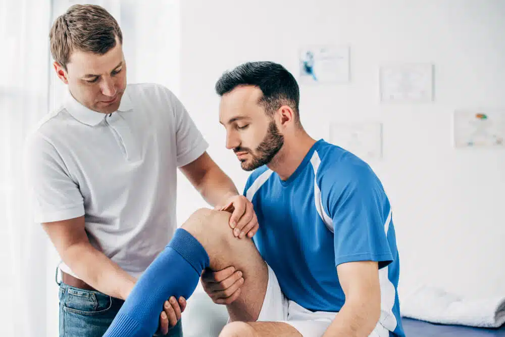 Athlete suffers from a sports injury getting a treatment in a chiropractic clinic