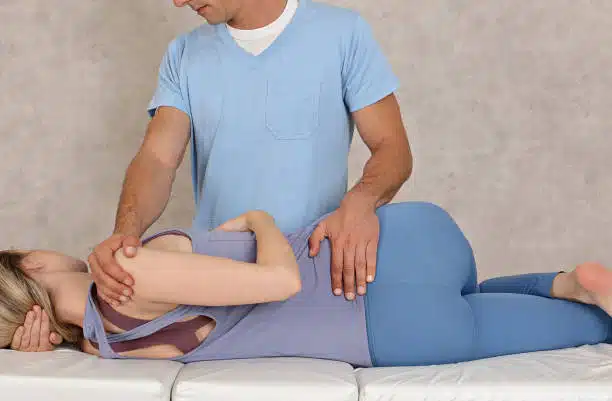 Chiropractor doing therapy to the patient with scoliosis