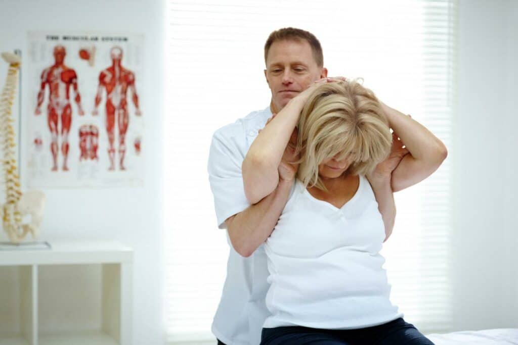 Chiropractor is treating a patient who suffers from auto accident by having a head and neck adjustment.