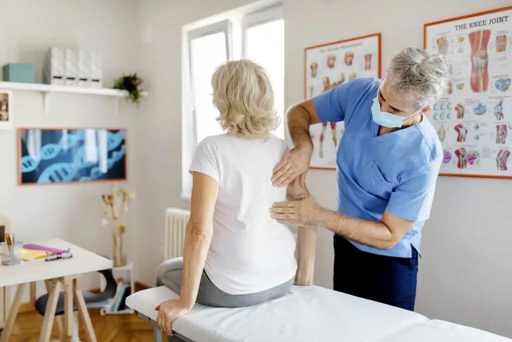 Chiropractor is doing some back and spinal adjustment to the patient.