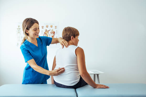 Chiropractor doing spine adjustment on male patient.