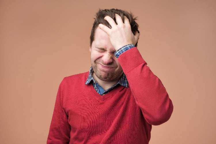 Man holding his head feeling of intense headache and migraine.