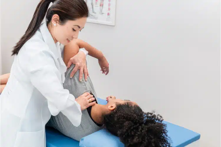 chiropractor doing some manual adjustment to the patients shoulder.