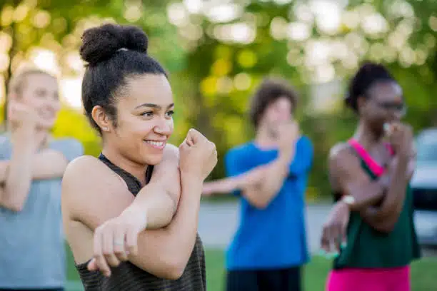 Group of women having an outdoor exercises and fitness training.