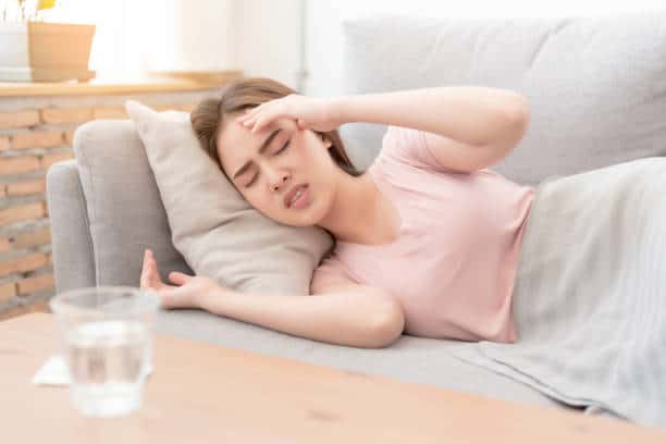 Woman on sofa having headache / migraine.