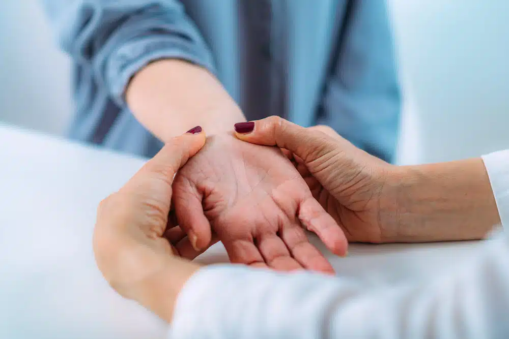 chiropractor examining the hand and wrist of the patient.