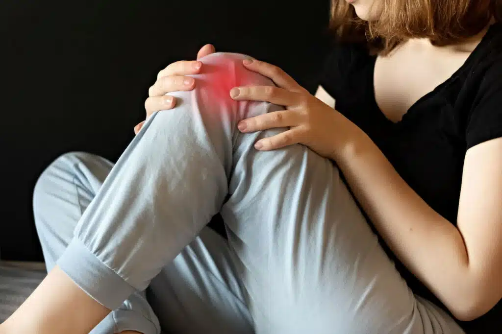 Woman suffers from intense knee pain.