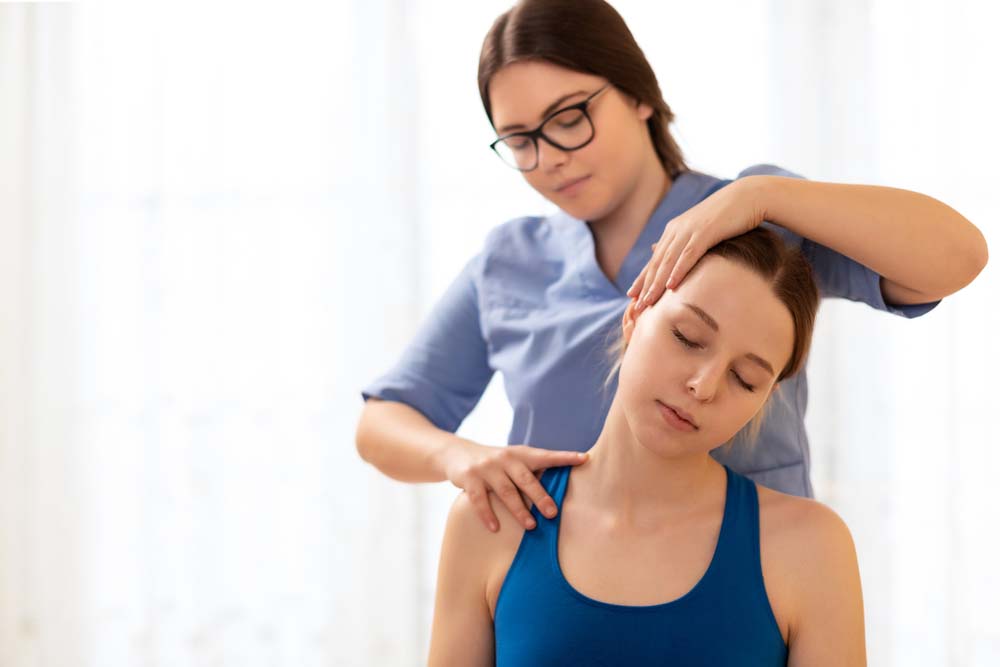 Female physiotherapist or a chiropractor adjusting patients neck. 