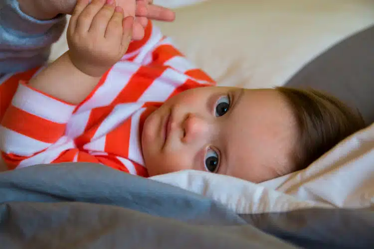 Baby boy with developmental delays lying on bed | pediatric chiropractic care in columbus