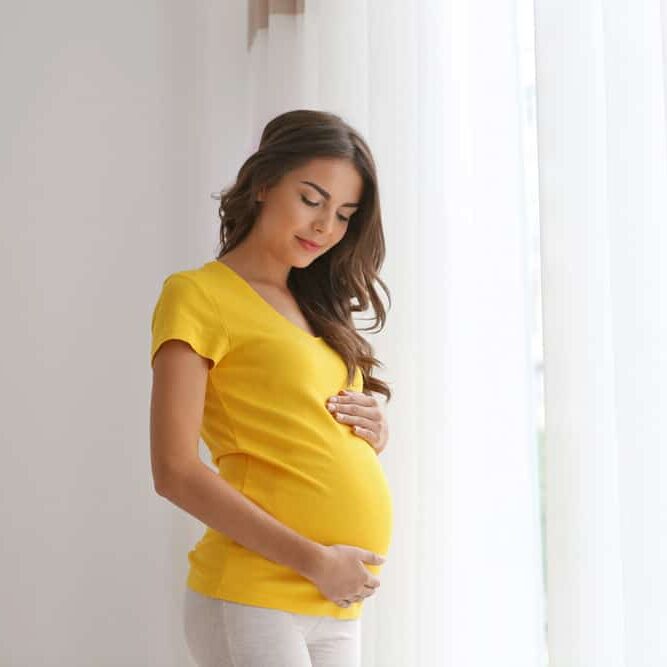 happy pregnant woman holding her belly.