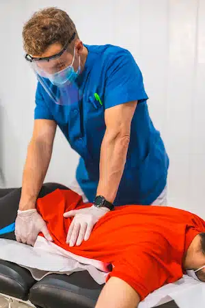 A physical therapist working the hip pain of a patient