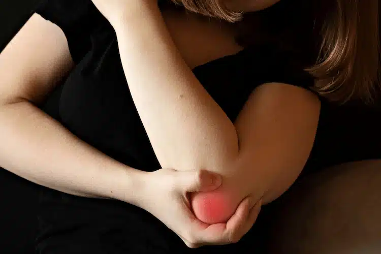 woman experiencing pain in the elbow joint and doing elbow pain treatment in columbus ne