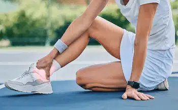 causes of foot and ankle pain treatment in columbus ne: woman tennis player getting her ankle injured during training
