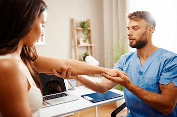 Our chiropractors approach: Chiropractor examining elbow of the patient