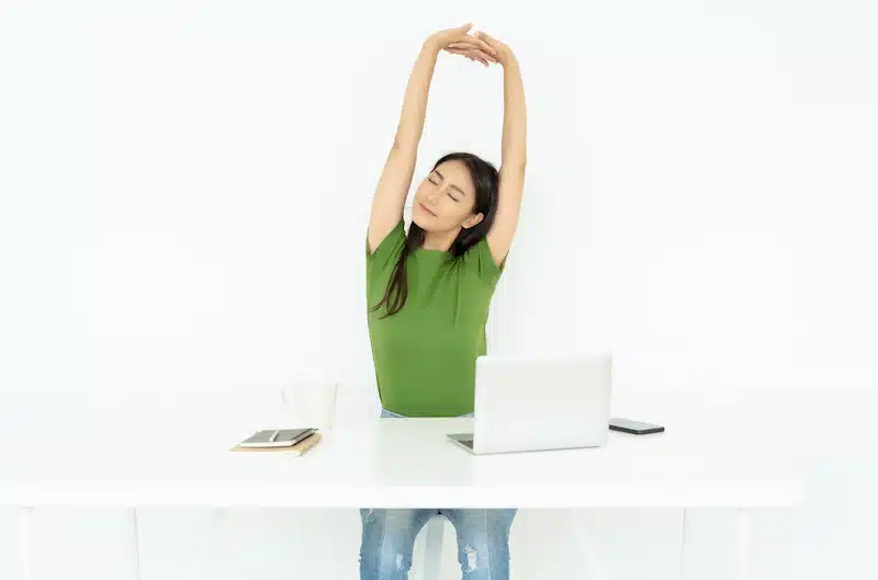 woman with a desk job doing a stretch to maintain good posture
