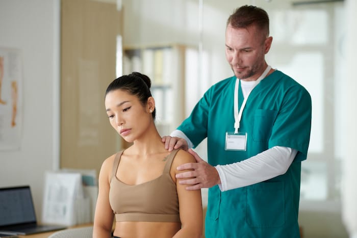 therapist palpating neck and shoulders
