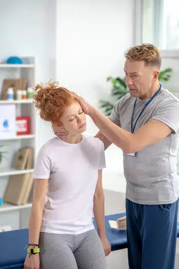 chiropractor doing neck exercises on patient's neck for headaches and migraines
