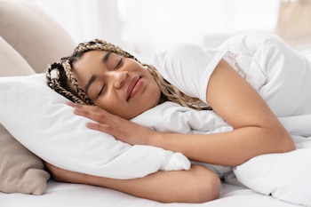 cheerful young african woman lying and sleeping