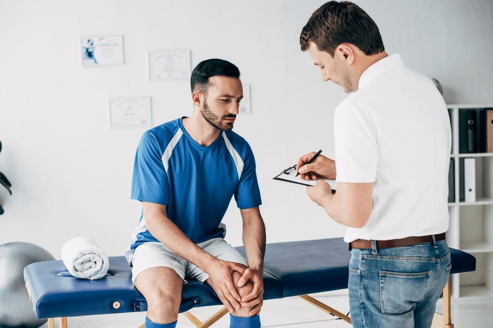 doctor consulting a sports injury patient | chiropractic myths