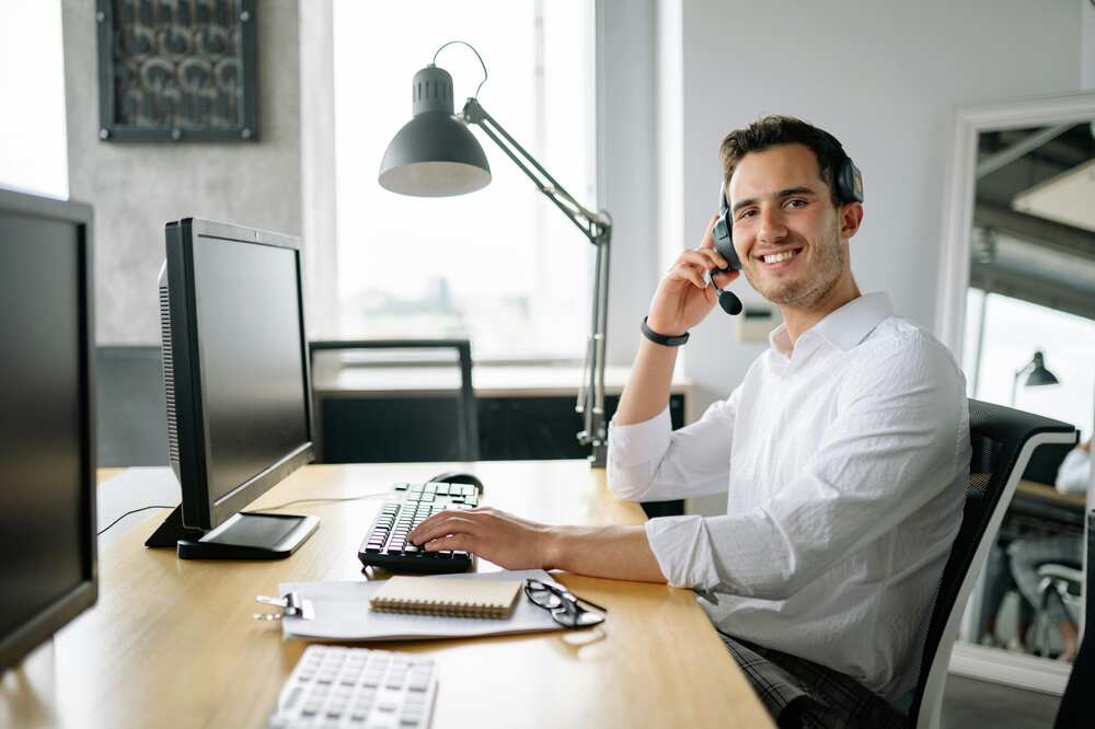 A male desk worker is happy at work
