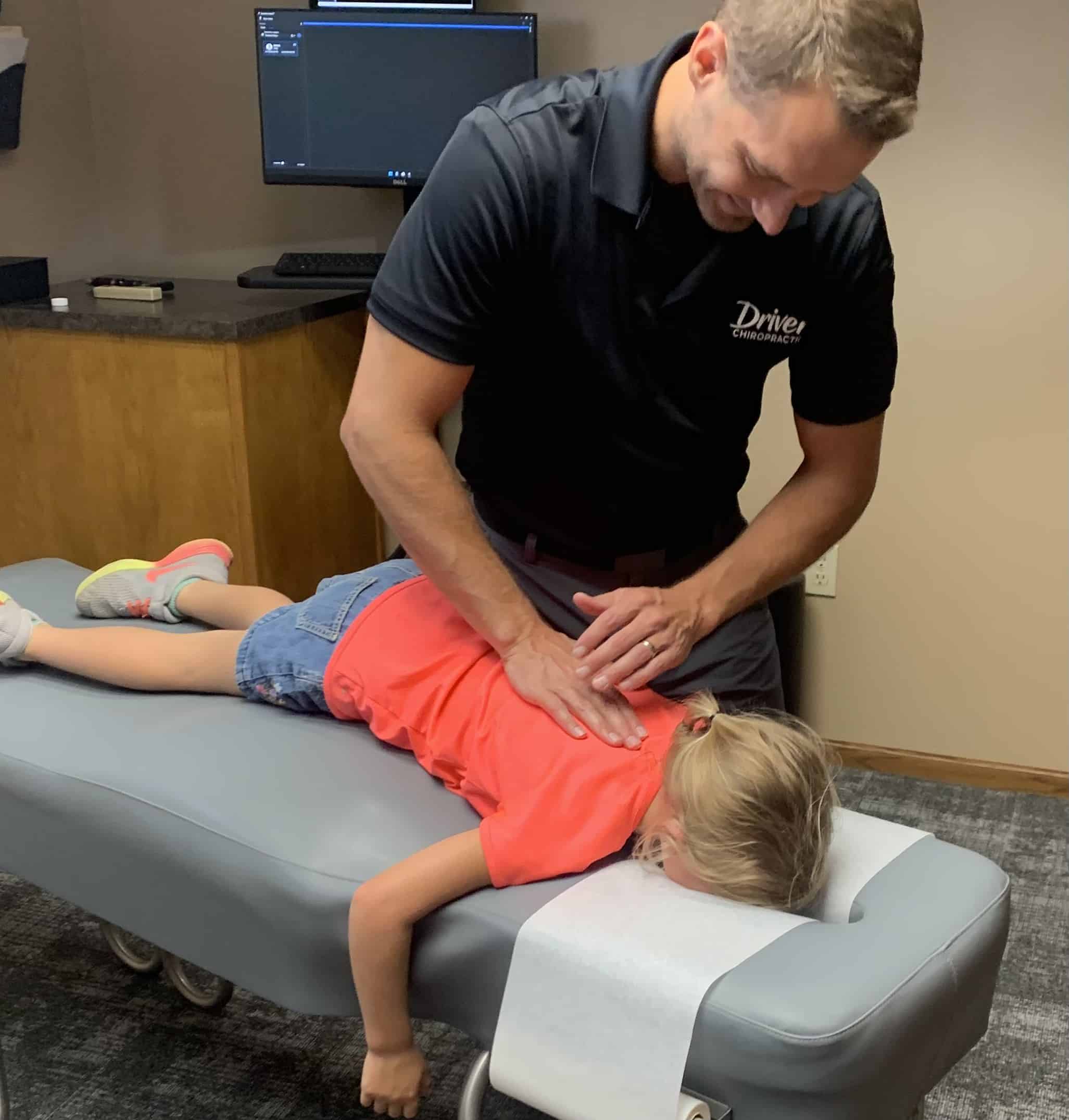 pediatric chiropractic care in Columbus doing some back adjustment to a young patient.