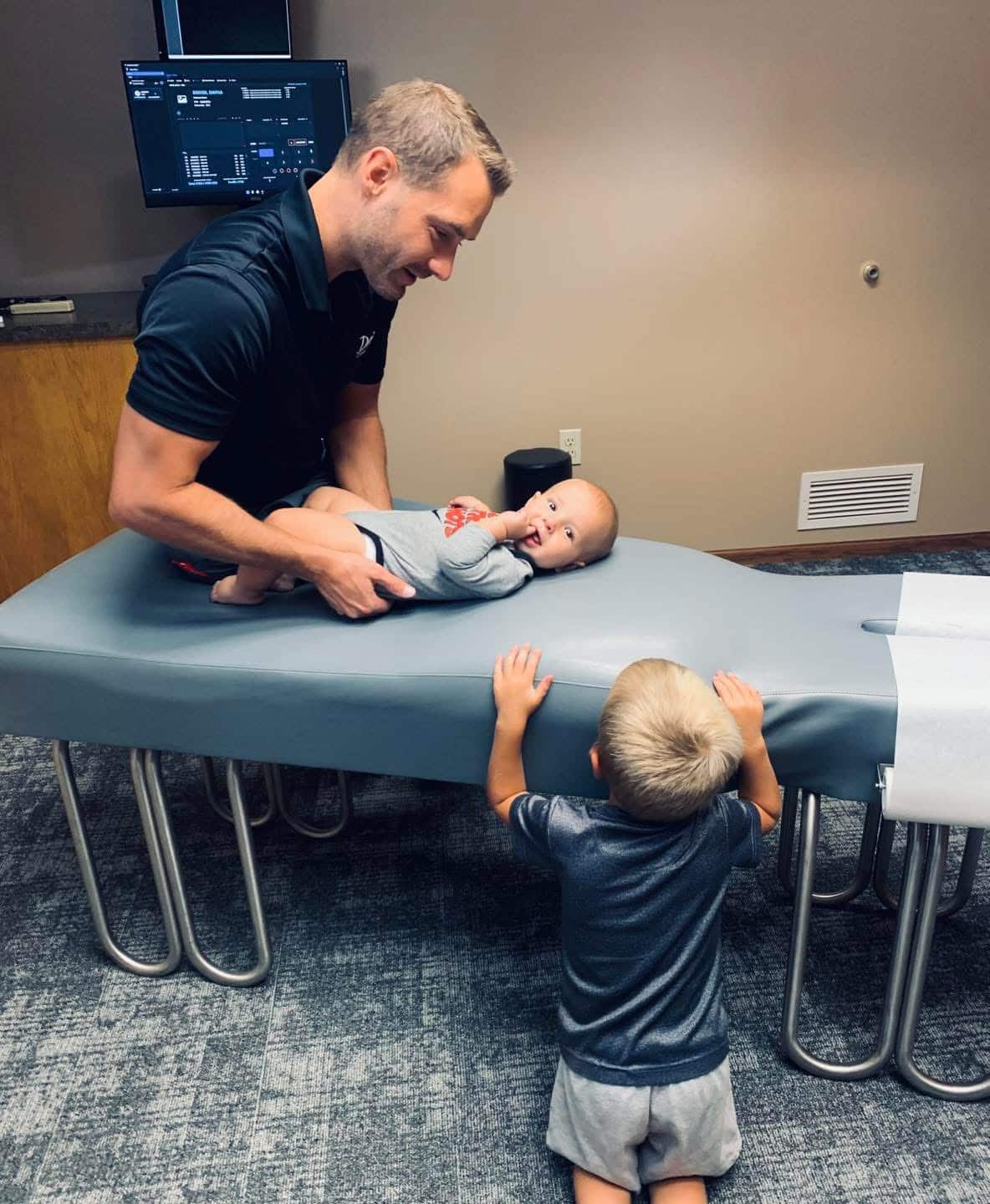 Pediatric chiropractor doing stretching exercises with her young patient.