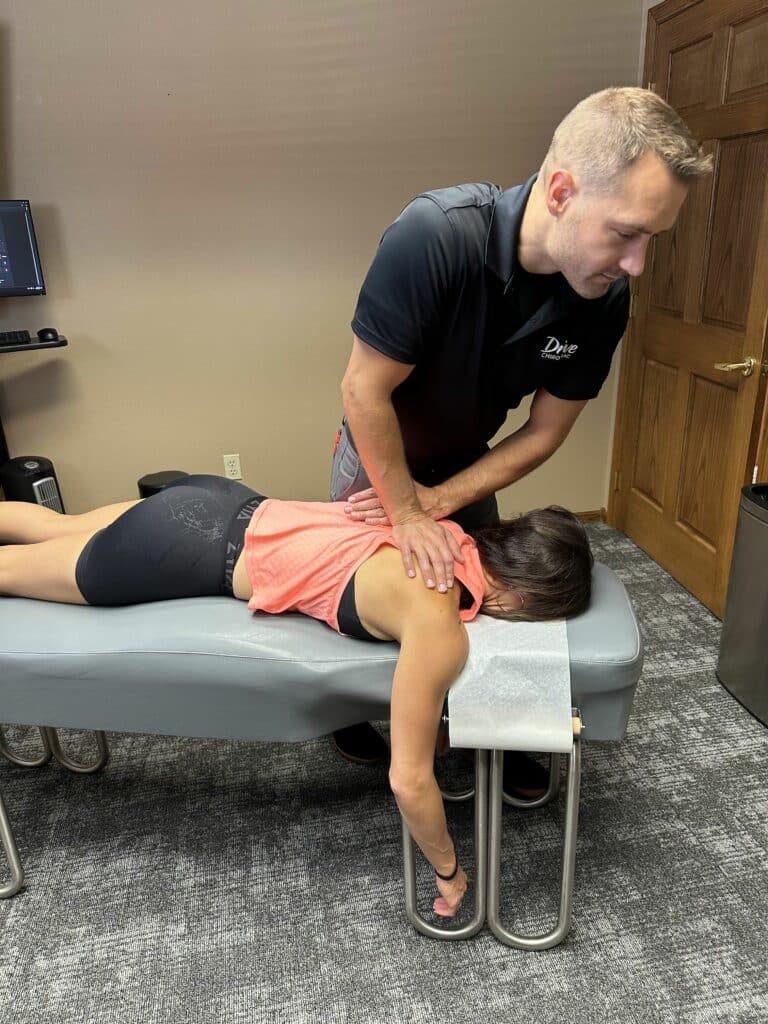 shows a chiropractor applying controlled force to the spine or neck to improve alignment and mobility.